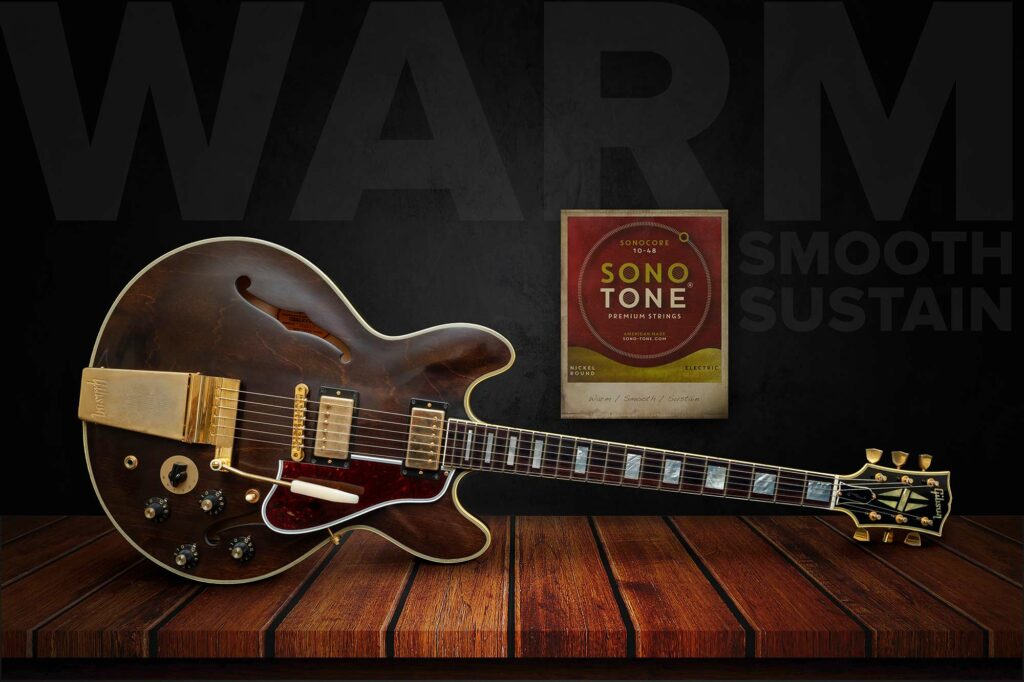 Large-format hero pairing a brown Gibson ES-355 with a SonoCore string pack and ghosted Warm / Smooth / Sustain wordmarks on rustic planks.