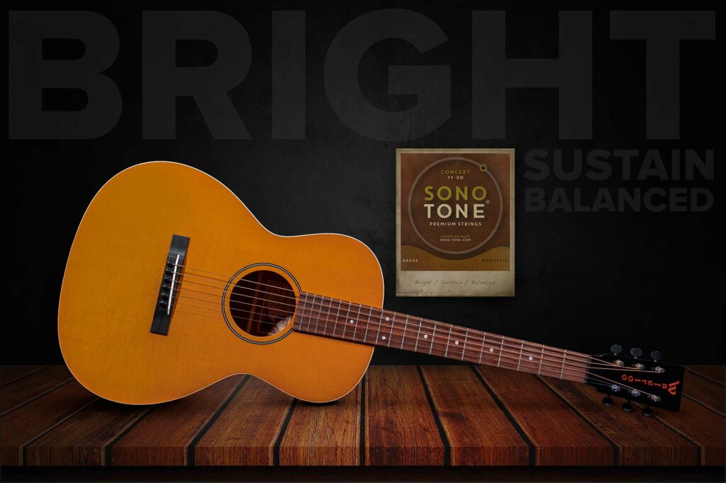 Amber concert acoustic with a SonoTone Concert string pack on wood planks, Bright / Sustain / Balanced set behind.