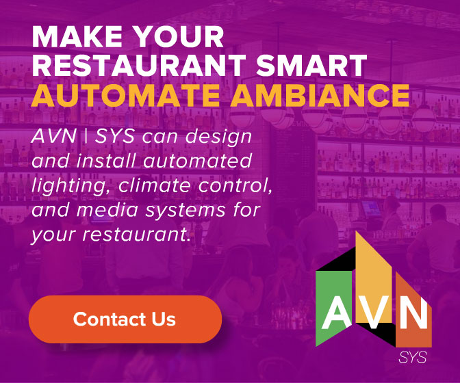 AVN | SYS restaurant display ad, 'Make Your Restaurant Smart — Automate Ambiance,' promoting automated lighting, climate control, and media systems, on a purple bar-interior backdrop with the AVN logo.