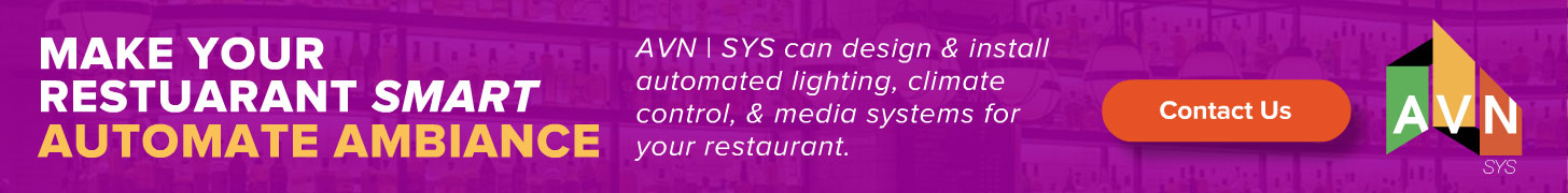 AVN | SYS restaurant display ad, 'Make Your Restaurant Smart — Automate Ambiance,' promoting automated lighting, climate control, and media systems, on a purple bar-interior backdrop with the AVN logo.