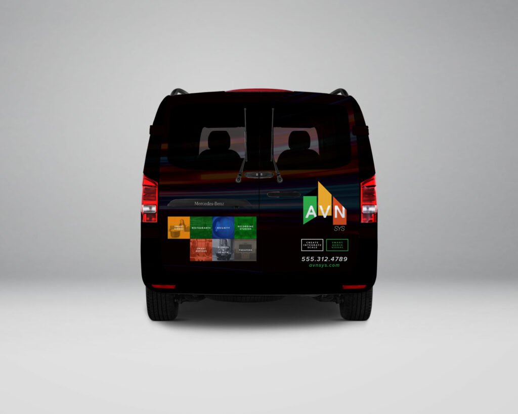Rear view of the AVN | SYS service van wrap, with the logo, service-category tiles, badges, and avnsys.com contact details across the rear doors.