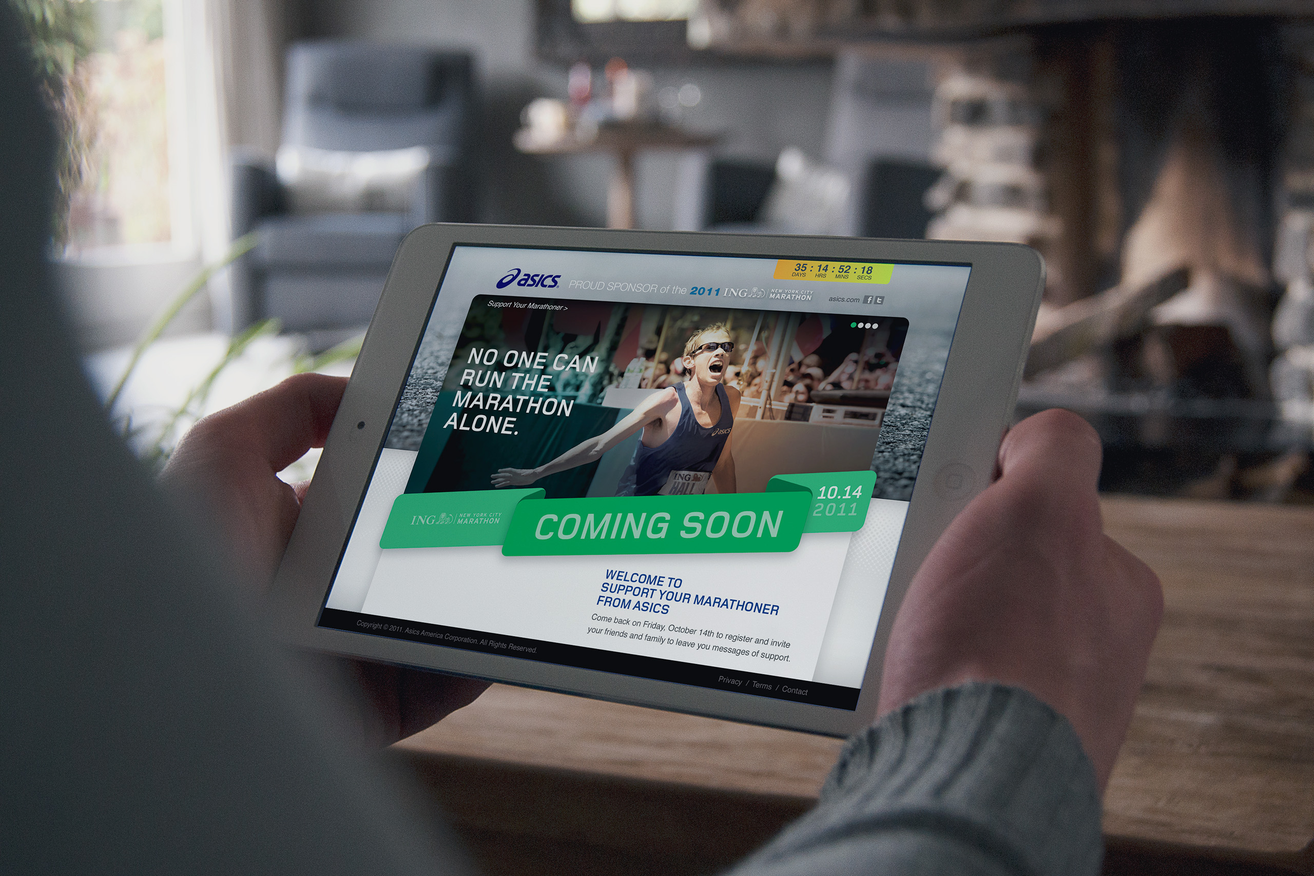 Tablet by a fireside window showing the Support Your Marathoner coming-soon page, green ribbon banner over the No One Can Run the Marathon Alone hero.