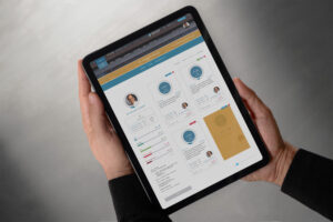 Physician profile in Streamline held on an iPad, pairing the doctor’s portrait and goal progress bars with trial cards carrying circular completion rings.