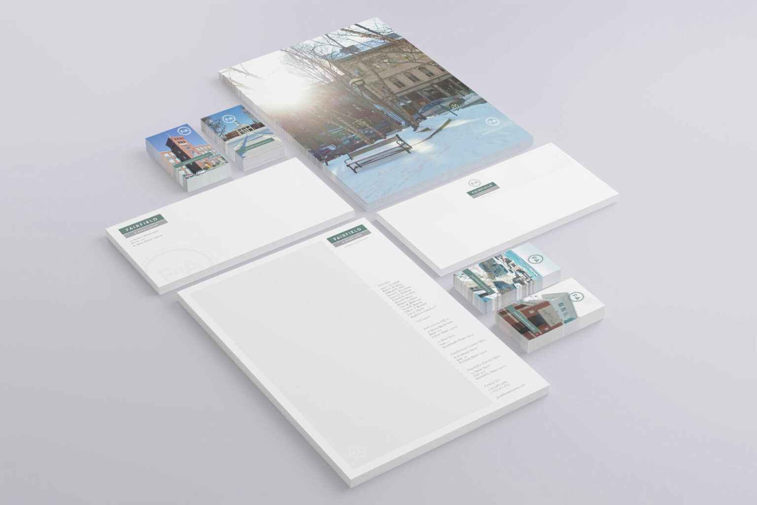 Stationery system in isometric view showing alternate business card backs, brick architecture and courthouse photography joining the letterhead and envelopes.