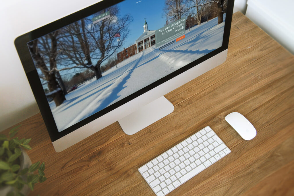 Fairfield & Associates website on an iMac viewed from above, the snow-covered York County Courthouse hero framing the We are Adaptive to Our Clients’ Needs message.