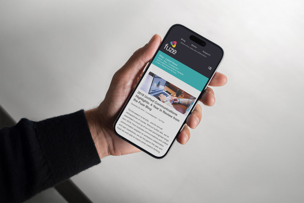 Fuze blog article on an iPhone in hand, the 2016 Unified Communications year-in-review post under the teal category banner.