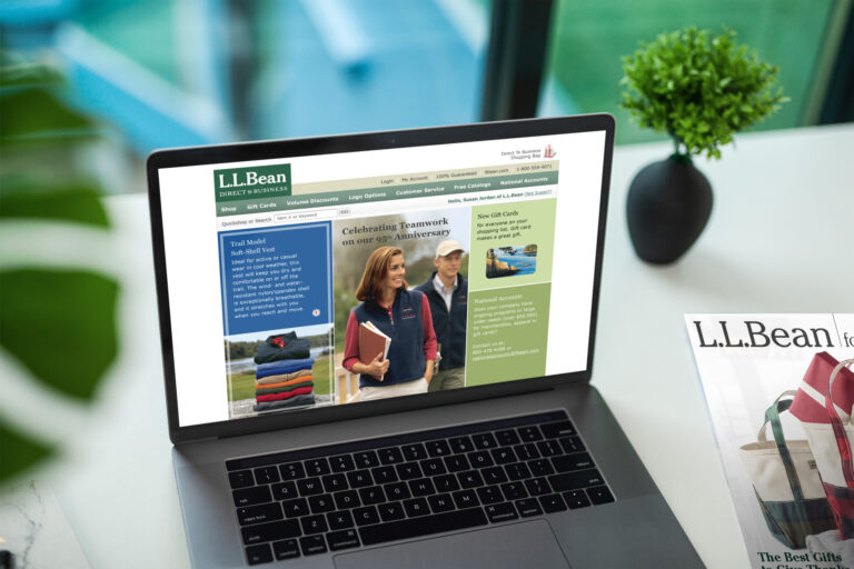 Laptop on a marble desk showing the Direct to Business homepage celebrating 95 years of teamwork, catalog cover at right.