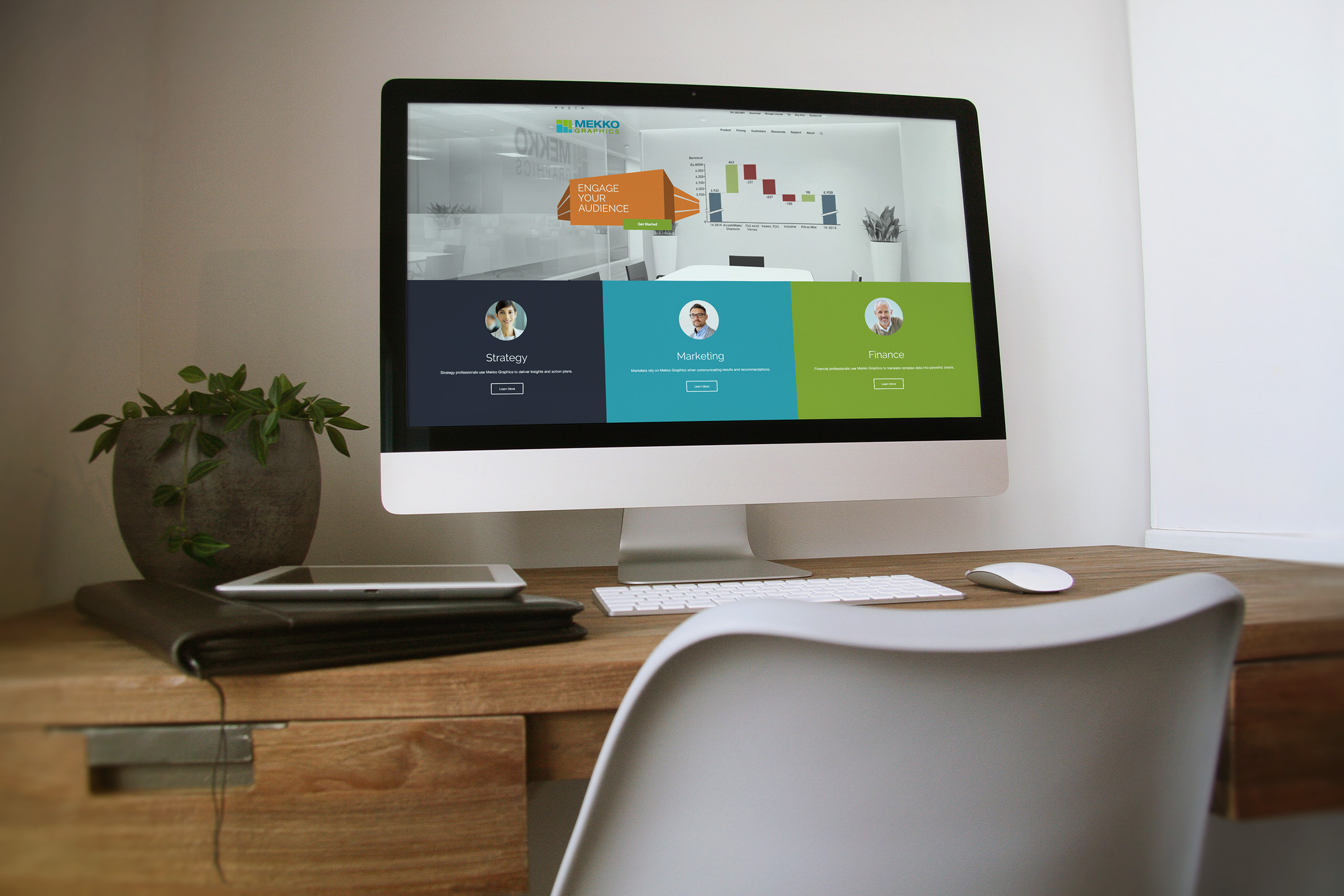 Desktop monitor on a wood desk showing the homepage hero with an orange Engage Your Audience chart over Strategy, Marketing, and Finance panels.