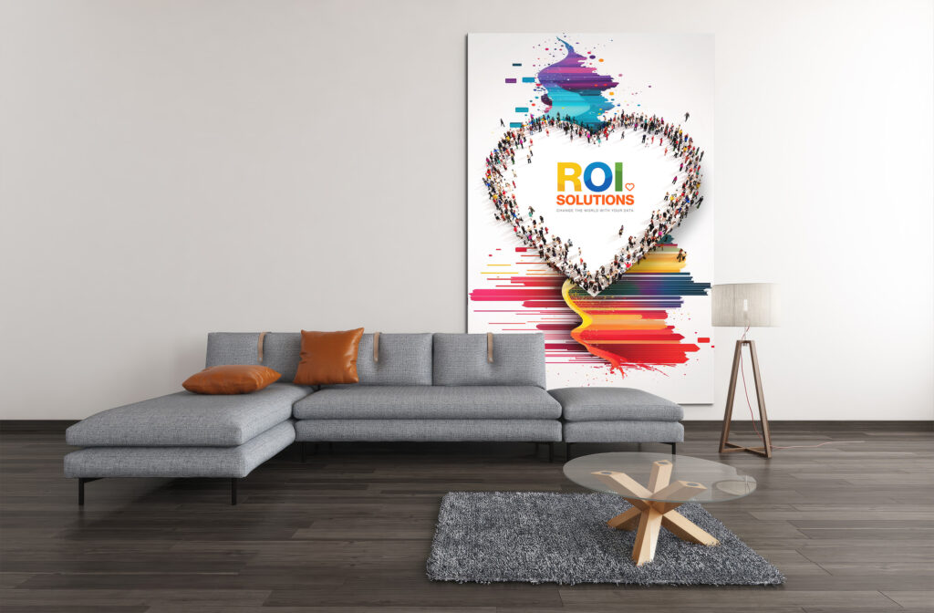 Virtual meeting backdrop of a gray sectional beside the tall crowd-heart canvas dripping paint colors down the wall.