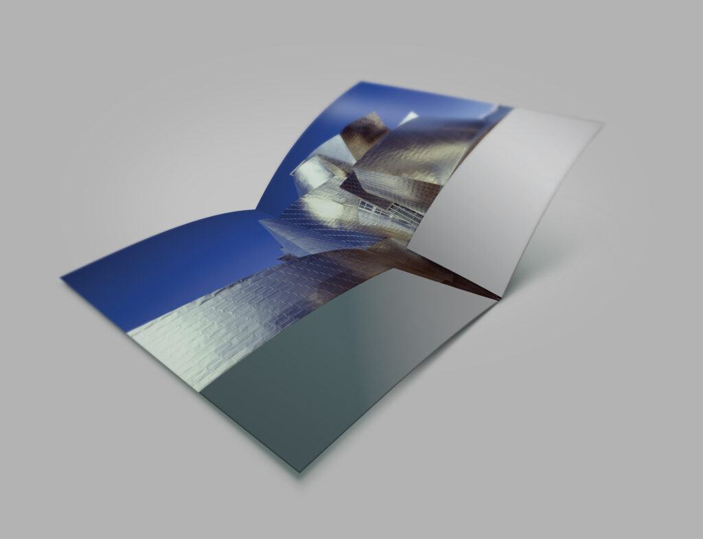 Press kit folder opening to full-bleed Guggenheim Bilbao photography, titanium curves spilling across both panels.