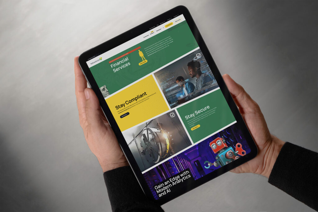 Hands hold a tablet showing the green Financial Services page, Stay Compliant and Stay Secure panels around a vault door and toy robot.