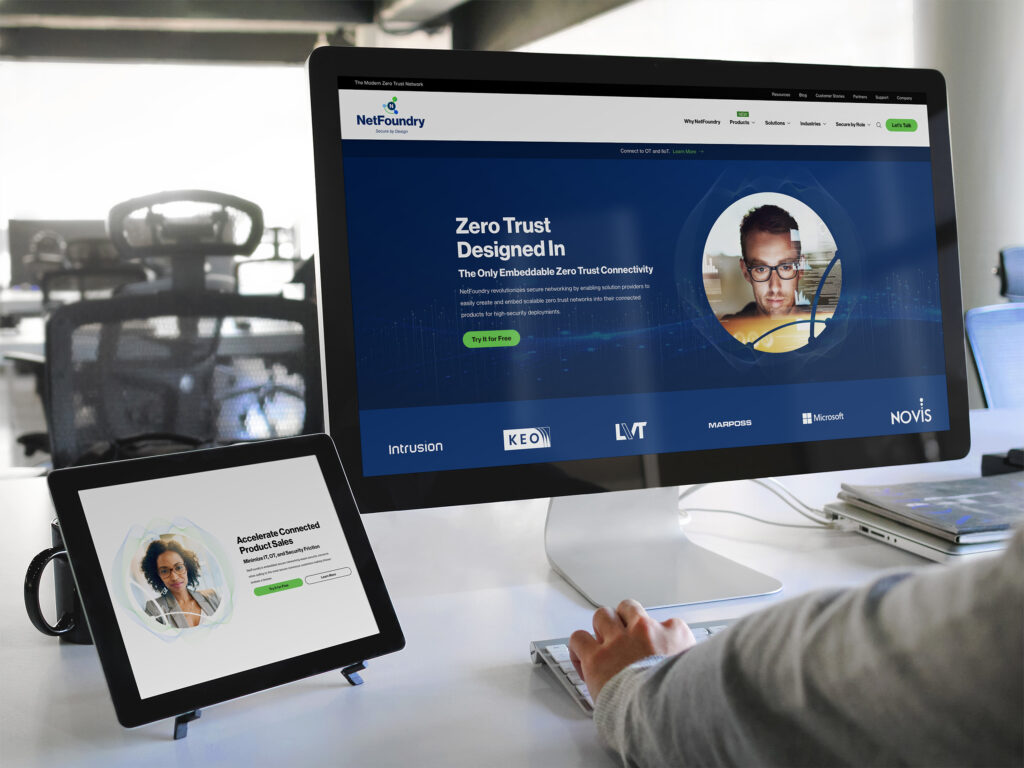 Desk with the homepage hero on a monitor and the product sales persona page propped on a tablet beside it.