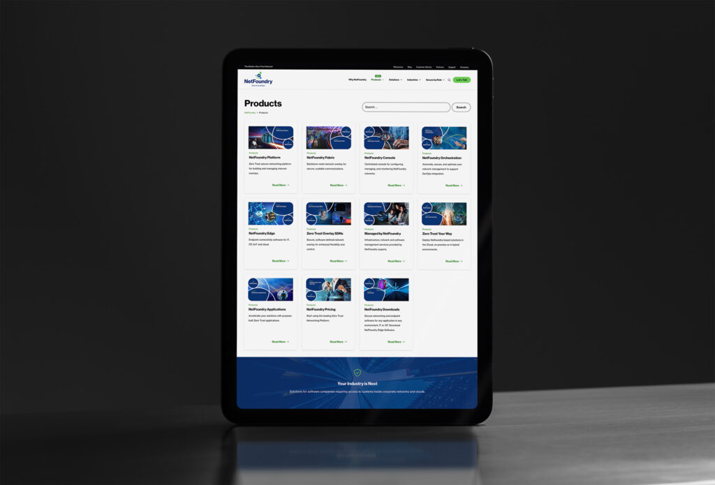 Tablet standing on steel showing the Products index, a dozen navy product cards from platform to downloads.