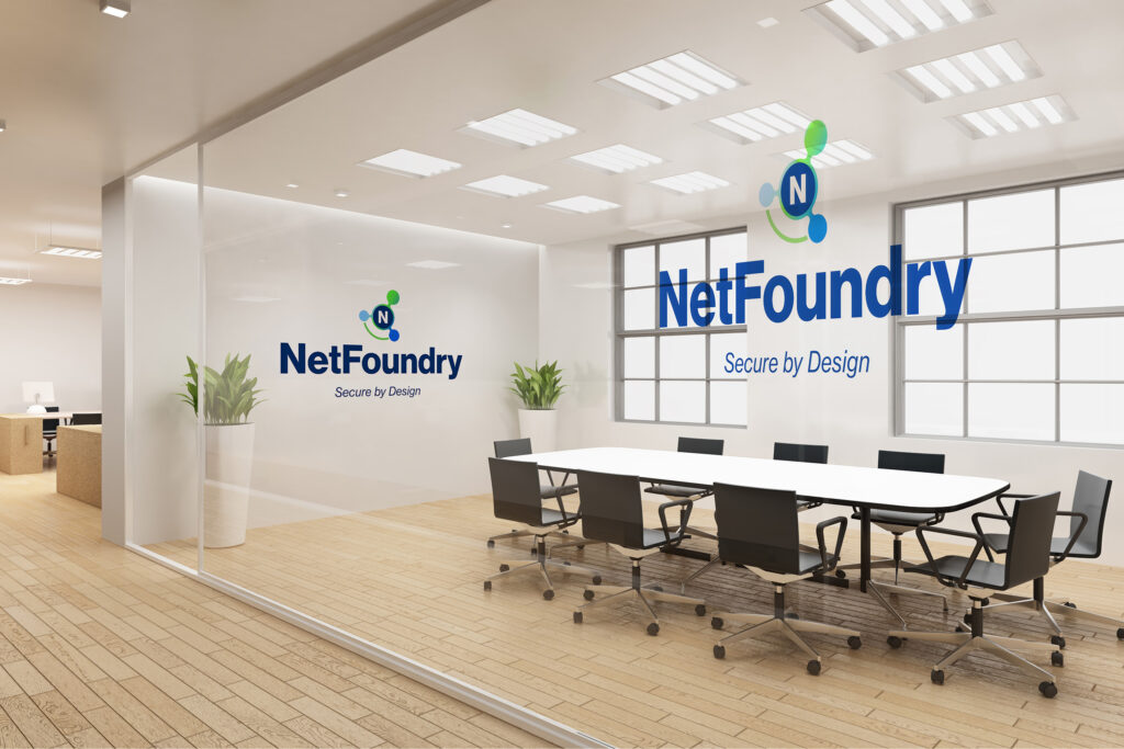 Virtual meeting backdrop of a glass conference room, the logo on the wall and the Secure by Design mark on the window.