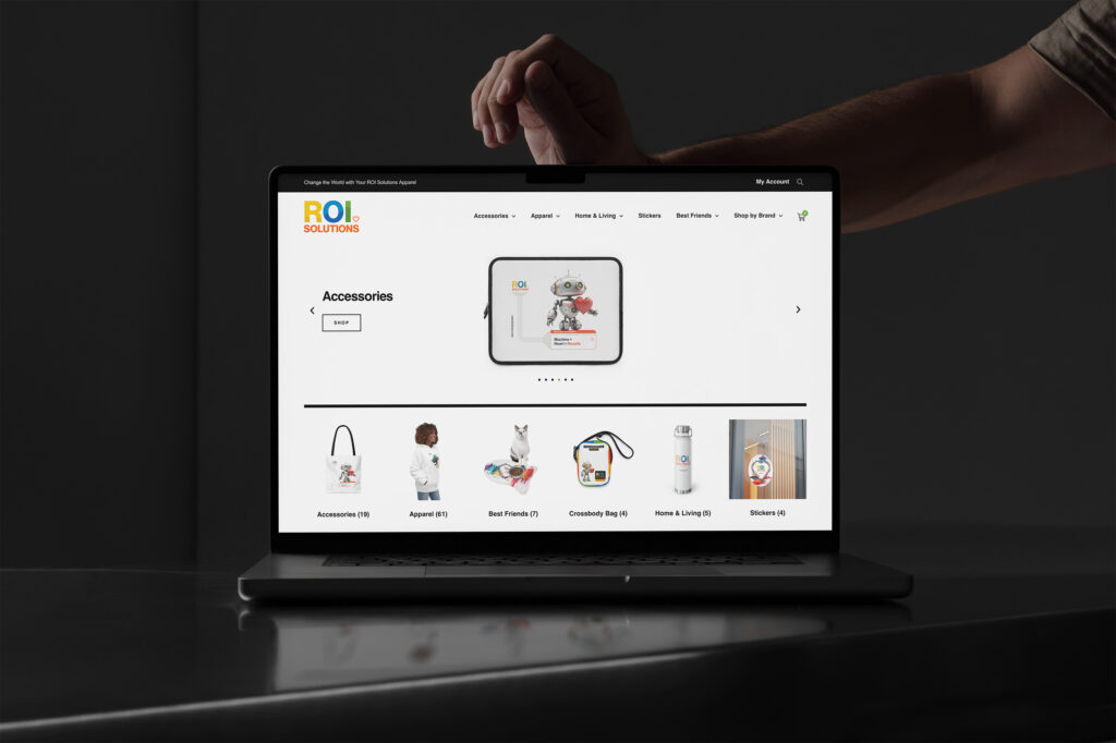 Laptop showing the merch store accessories carousel above the category tiles running from apparel to stickers.