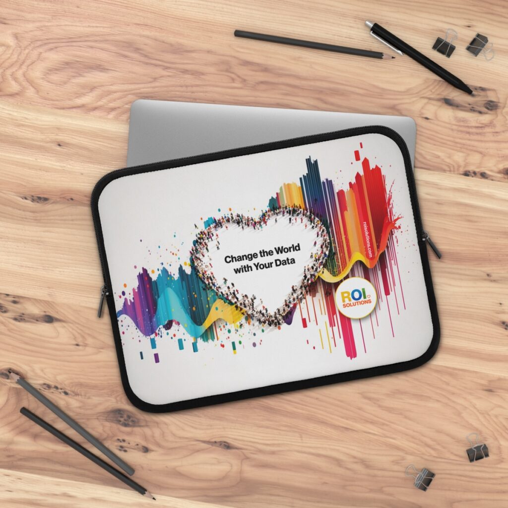 White laptop sleeve on a wood desk, the crowd heart and brand promise printed over rainbow streaks.