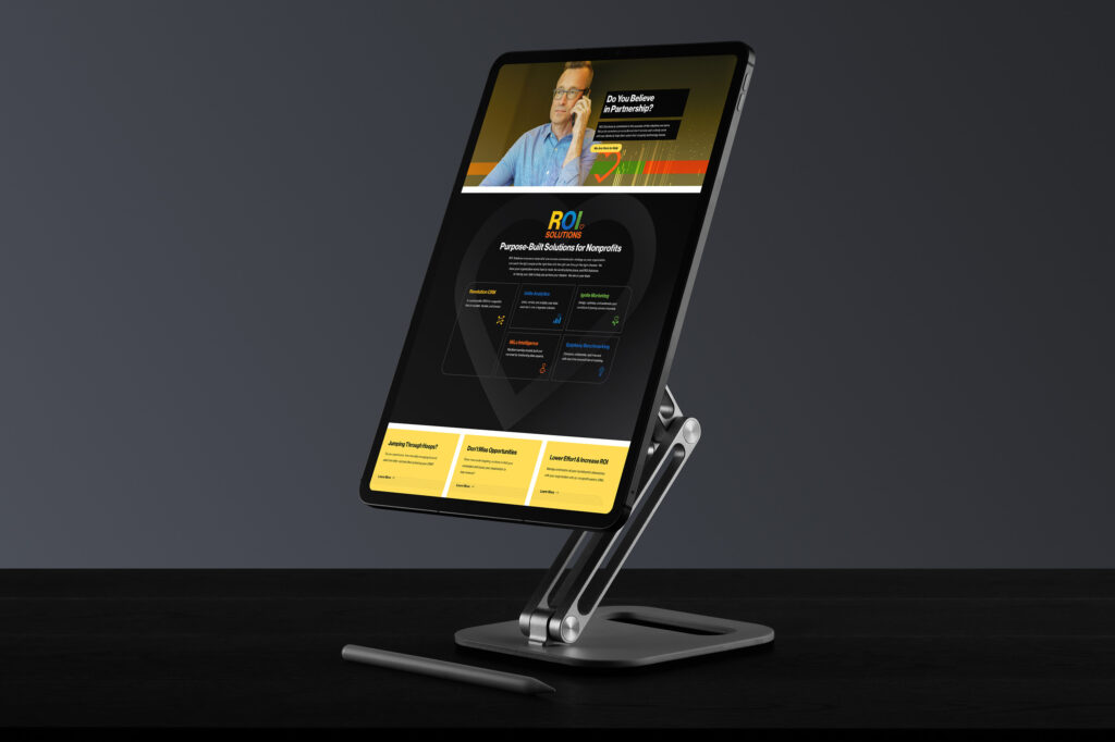 Stand-mounted tablet showing the partnership page, Do You Believe in Partnership above dark product panels and yellow cards.