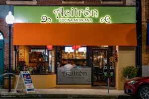 Acitron Cocina Mexicana green sign and orange awning lit at night, Arlington MA.