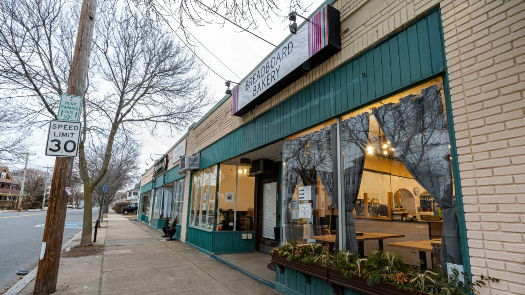 Breadboard Bakery at the corner of its block on a winter day, teal storefront under bare trees.