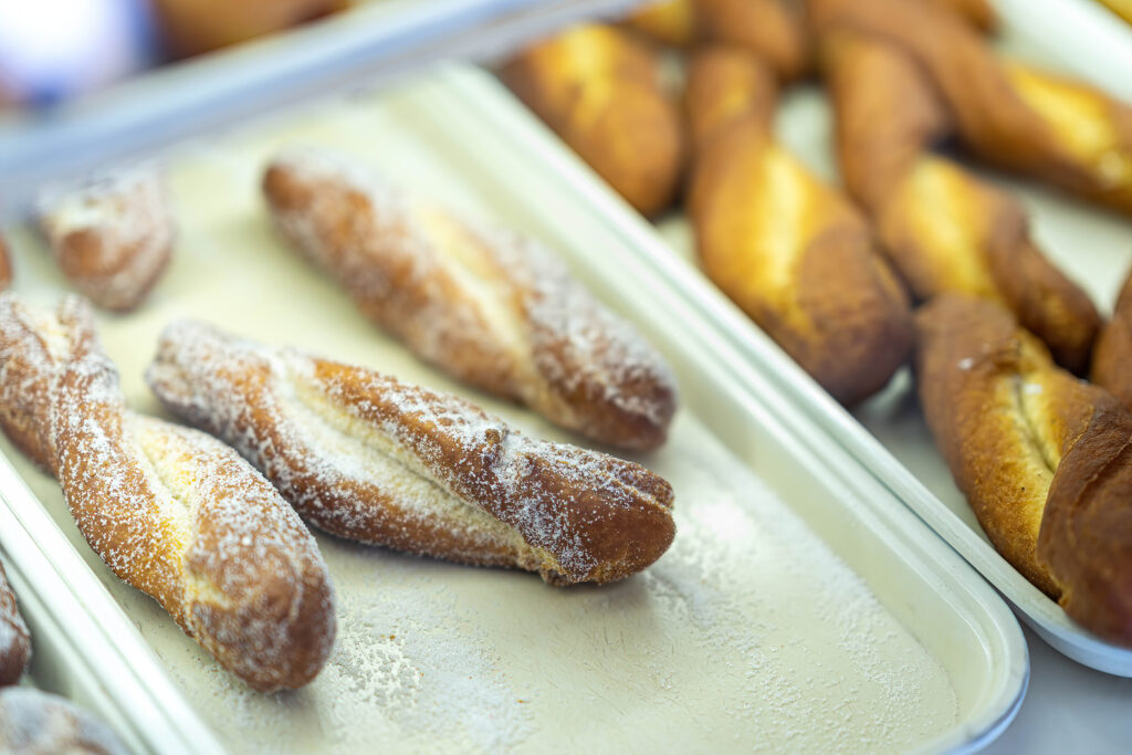 Sugared crullers and glazed donuts on trays at Gail Ann Coffee Shop.