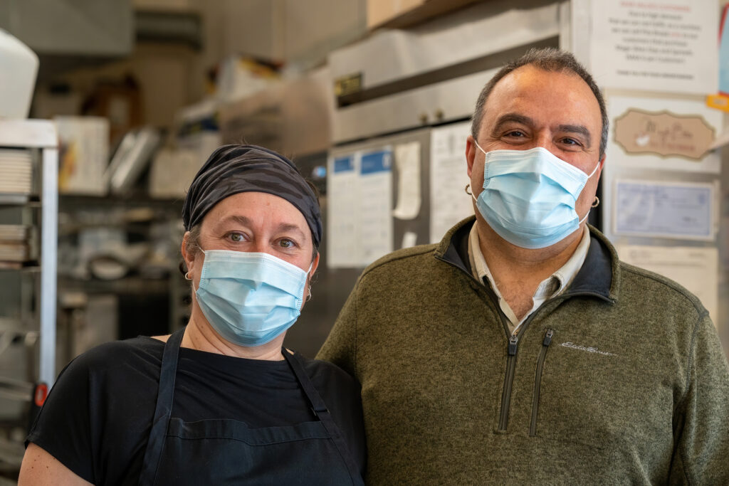 Owners Elif and Atilla Ozkefeli of Magic Bites Bakery in masks behind the counter.